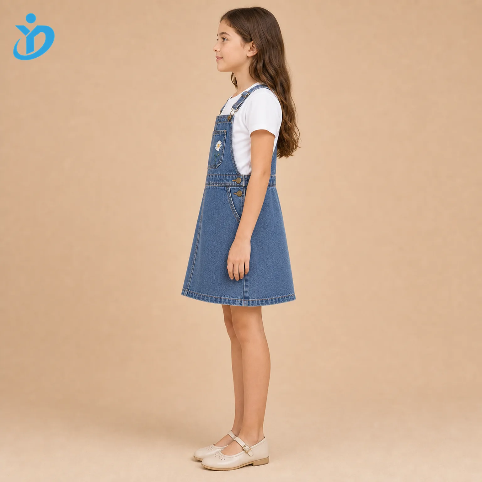 Full body side view of custom girls denim pinafore dress showing stone wash denim, adjustable straps, metal side buttons, A-line skirt, white T-shirt styling and Dongguan Yidi Clothing Co Ltd transparent logo