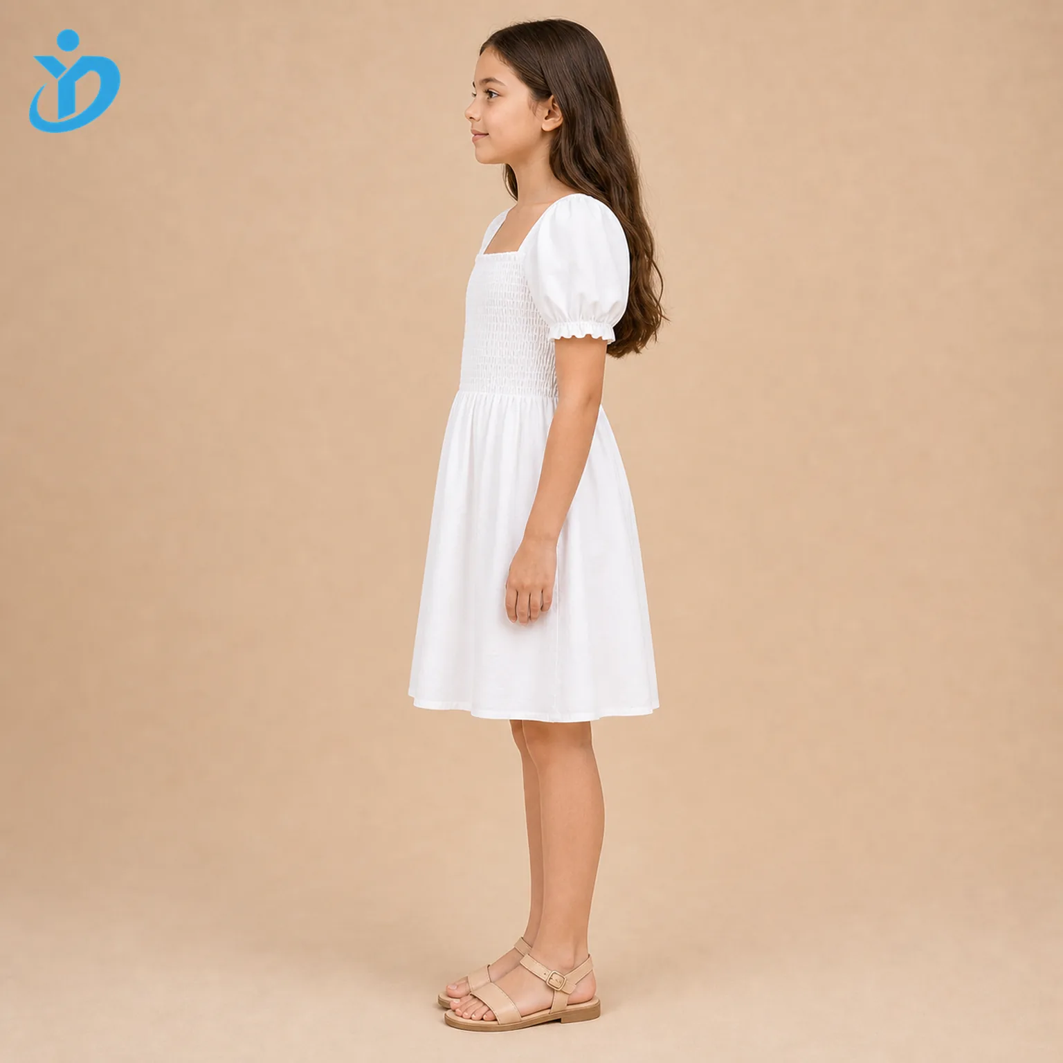 Full body side view of custom girls smocked dress showing white cotton fabric, smocked bodice, puff sleeve, A-line skirt drape and Dongguan Yidi Clothing Co Ltd transparent logo