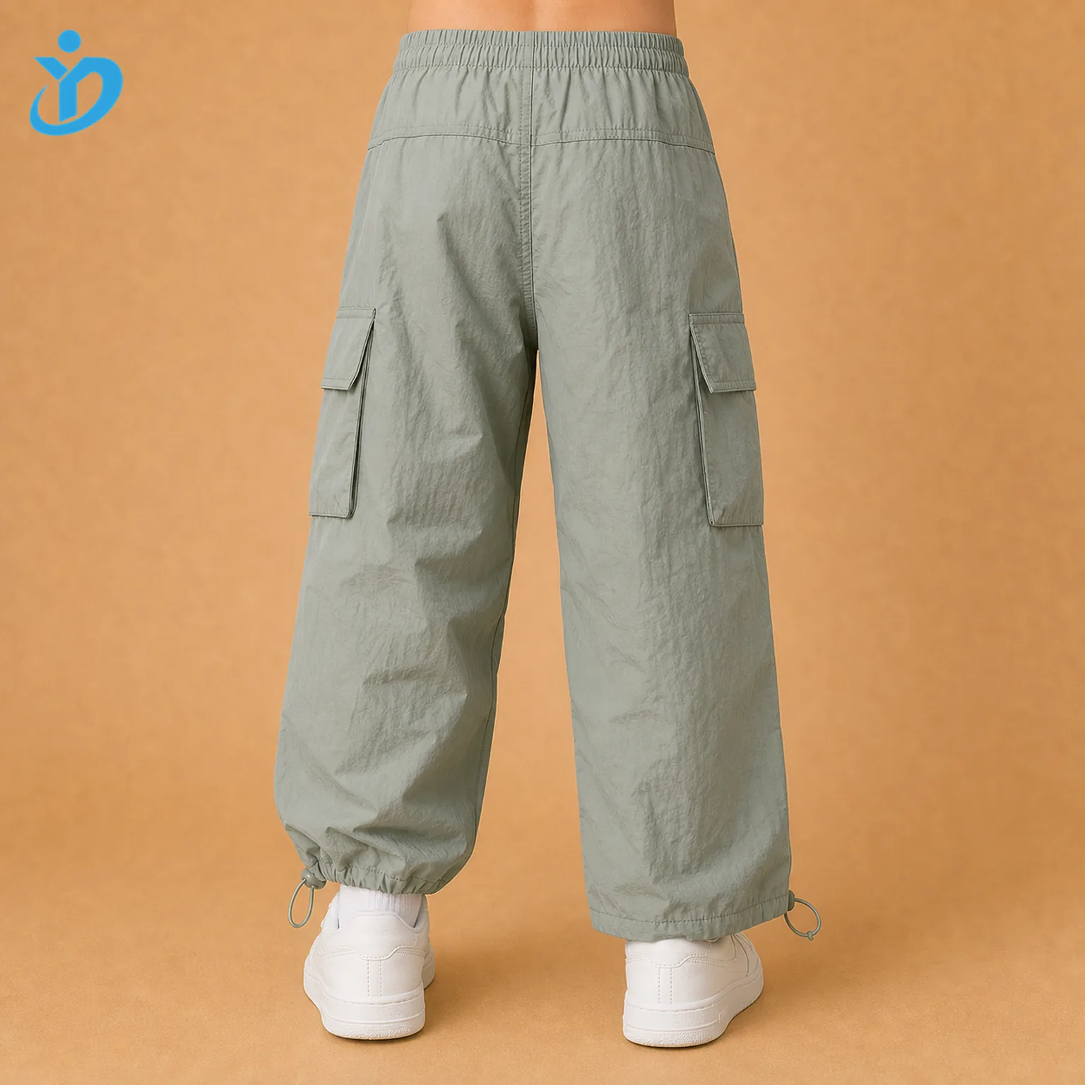 Lower body back view of custom kids lightweight parachute cargo pants with loose fit, cargo pockets, elastic waistband, adjustable hem cord and Dongguan Yidi Clothing Co Ltd transparent logo