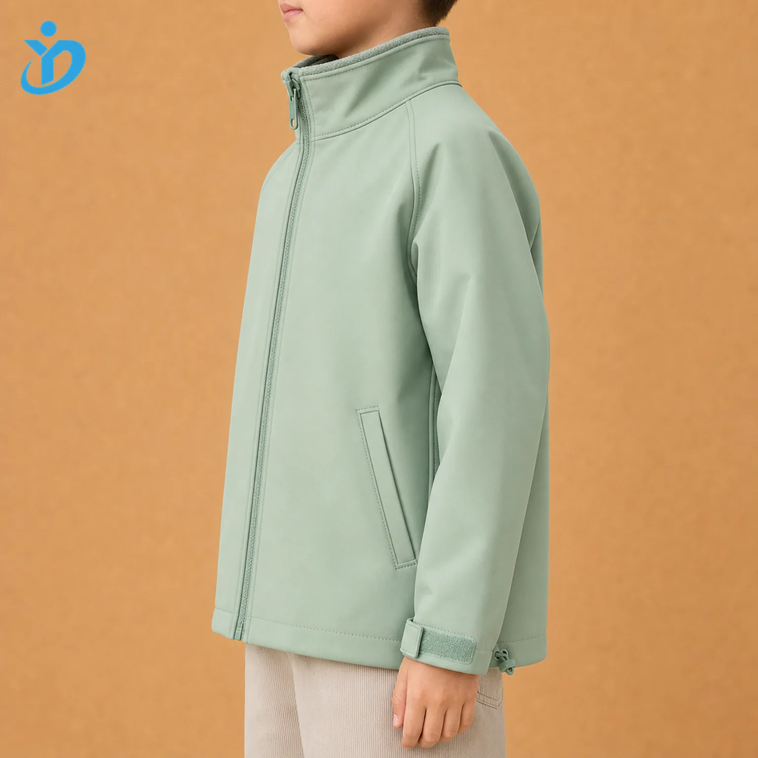 Upper body side view of custom kids softshell jacket in mint green showing waterproof zipper edge, bonded side pocket, Velcro cuff, hem drawcord and Dongguan Yidi Clothing Co Ltd transparent logo