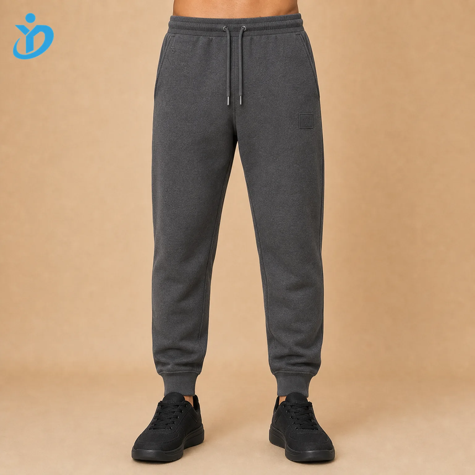 Lower body front view of custom mens heather charcoal French Terry fleece jogger pants with rib cuff elastic waistband drawcord silicone logo embroidery and Dongguan Yidi Clothing Co Ltd transparent logo