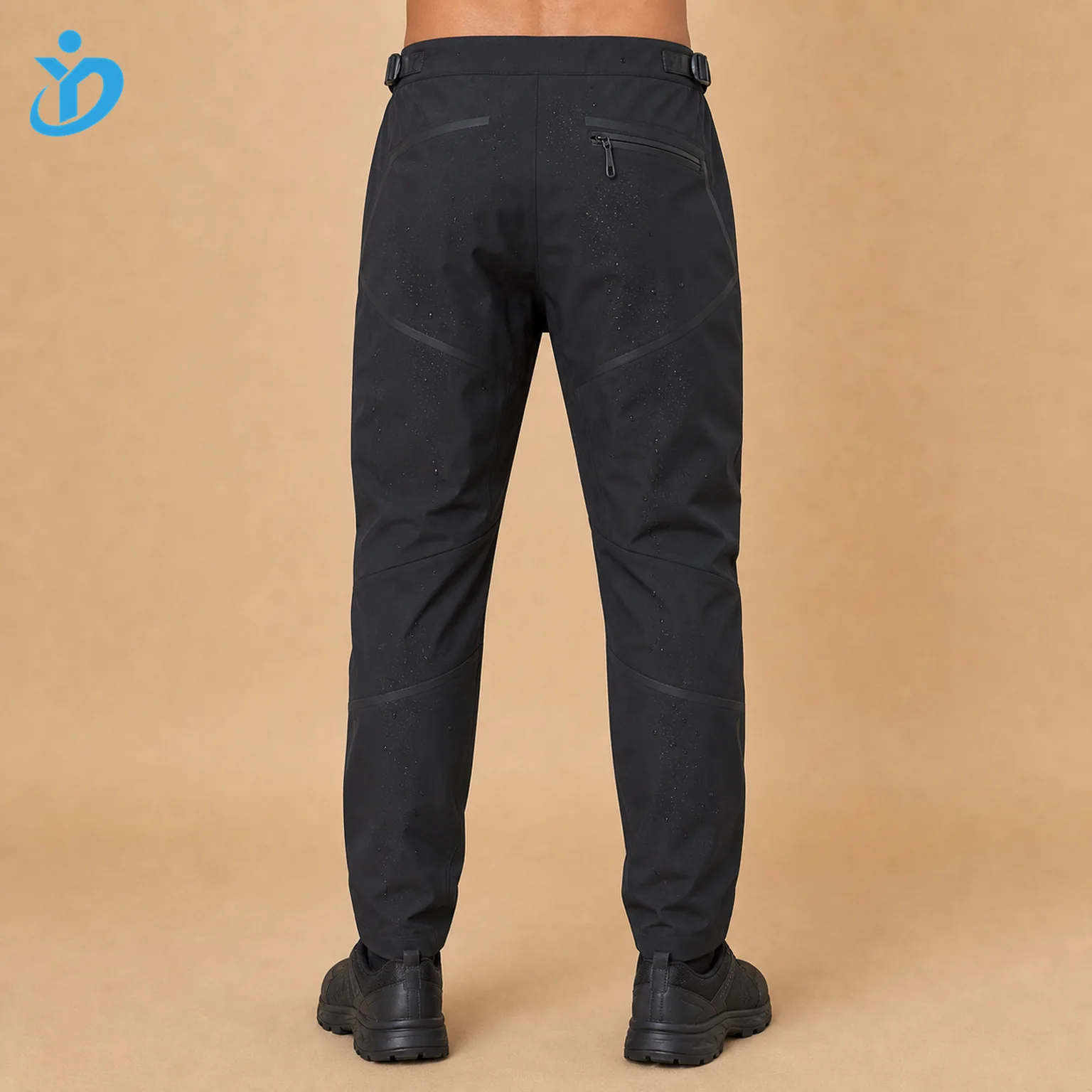 Lower body back view of custom mens matte black nylon spandex techwear pants showing waterproof zipper back pocket bonded seams laser cut panels adjustable waist tabs tapered fit and Dongguan Yidi Clothing Co Ltd transparent logo