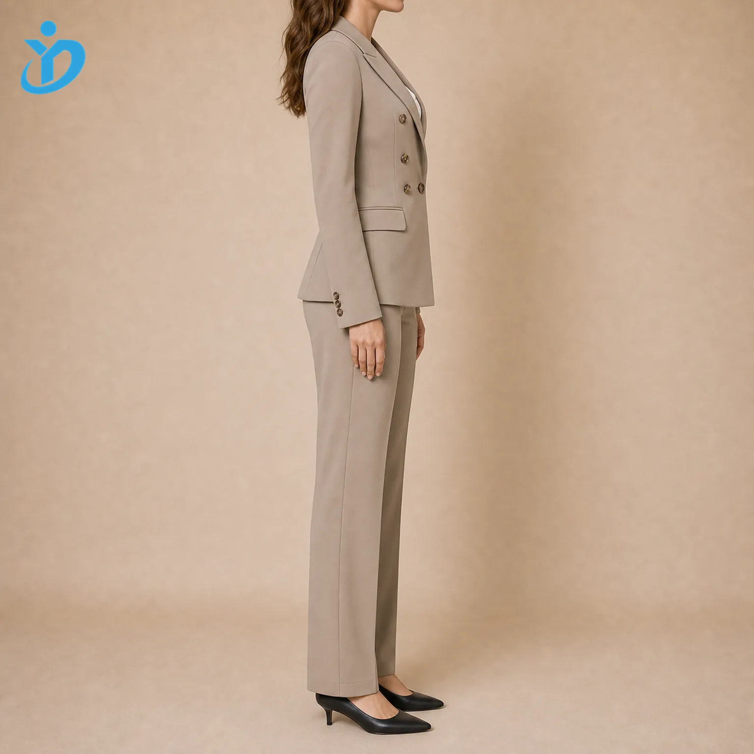 Custom womens double breasted suit sets side view showing taupe double breasted blazer high waist tailored trousers office corporate business style black heels and Dongguan Yidi Clothing Co Ltd transparent logo