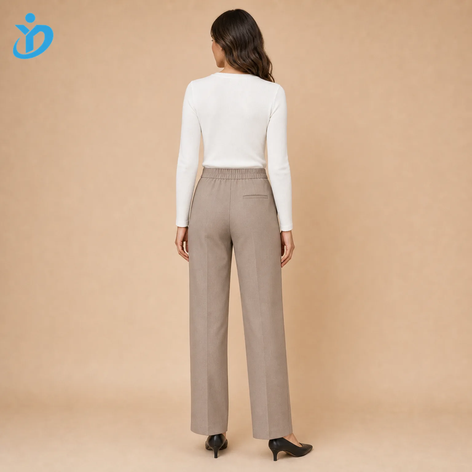 Custom womens straight leg pants back view showing elastic back waist welt back pocket straight leg cut taupe fabric white top black heels and Dongguan Yidi Clothing Co Ltd transparent logo